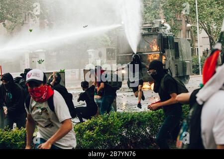 SANTIAGO, CHILE - 8. NOVEMBER 2019 - Molotov Cocktail wird bei den Protesten gegen die Regierung zur Wasserwerfer der Bereitschaftspolizei gestartet Stockfoto