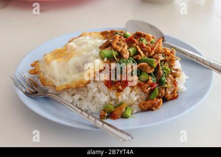 Kao-Pad-Kra-Prao (thailändisches Wort), würzige Speisen, Chiligerichte oder thailändischer Reis mit Schweinefleisch und Basilikum, thailändische Straßennahrung Stockfoto