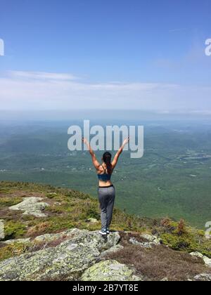 Frau, die beim Wandern in Maine USA die schöne Aussicht auf Hügel und Berge genießt Stockfoto
