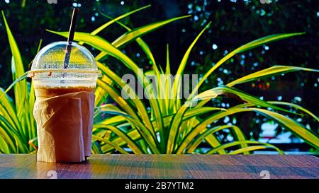 Kaffeetasse Kunststoff auf dem Tisch in der Sonne Morgen thailändischer Stil Stockfoto