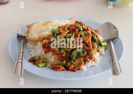 Kao-Pad-Kra-Prao (thailändisches Wort), würzige Speisen, Chiligerichte oder thailändischer Reis mit Schweinefleisch und Basilikum, thailändische Straßennahrung Stockfoto