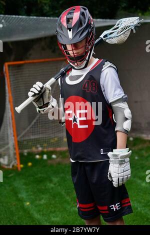 Ein Teenager posiert für Porträts in seiner Lacrosse-Uniform. Stockfoto