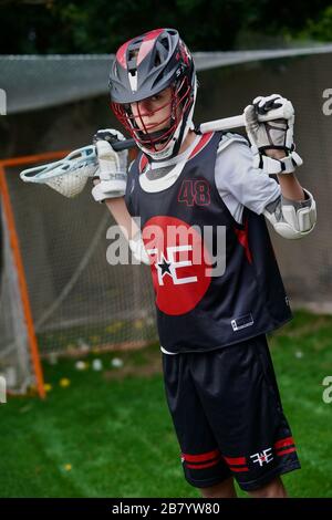 Ein Teenager posiert für Porträts in seiner Lacrosse-Uniform. Stockfoto