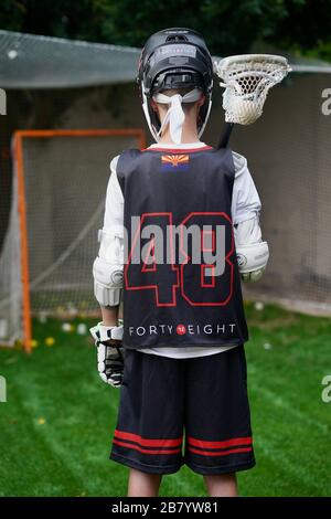 Ein Teenager posiert für Porträts in seiner Lacrosse-Uniform. Stockfoto