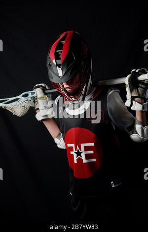 Ein Teenager posiert für Porträts in seiner Lacrosse-Uniform. Stockfoto