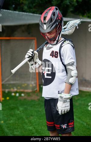 Ein Teenager posiert für Porträts in seiner Lacrosse-Uniform. Stockfoto