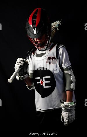 Ein Teenager posiert für Porträts in seiner Lacrosse-Uniform. Stockfoto