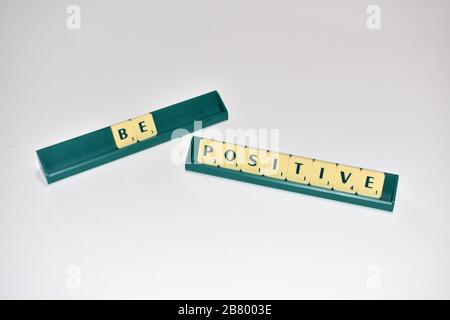 Scrabble Spielsteine sind positiv. Motivationszitat Scrabble blockiert Briefe Grauer Hintergrund Lebenszitat induzieren Alphabet. Stockfoto