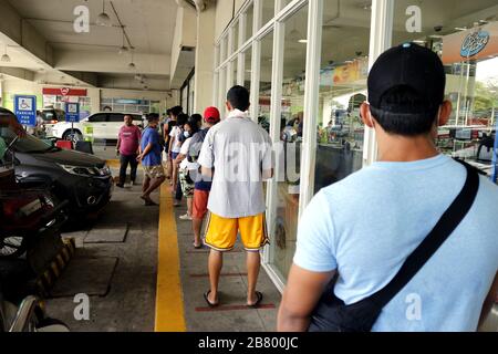 Antipolo City, Philippinen - 18. März 2020: Die Kunden sind weit voneinander entfernt, und zwar außerhalb eines Lebensmittellagers im Einklang mit der Regierungsca Stockfoto