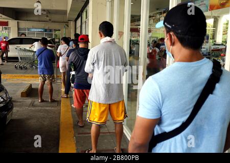 Antipolo City, Philippinen - 18. März 2020: Die Kunden sind weit voneinander entfernt, und zwar außerhalb eines Lebensmittellagers im Einklang mit der Regierungsca Stockfoto