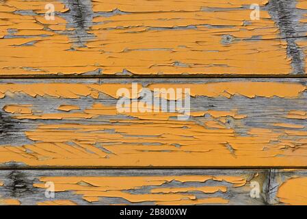 Nahaufnahme und Nahaufnahme, Textur und Hintergrund von verwitterten Holzlatten mit gelber Farbe, die sich abblättert Stockfoto