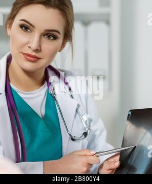 Doktor der weiblichen Medizin zeigt auf Röntgenbild Stockfoto