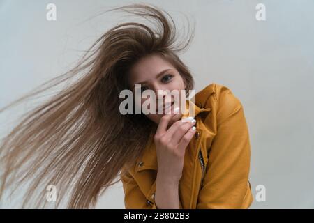 Junges faires Mädchen mit langen, fliegenden Haaren im Studio, Weitwinkelobjektiv und Blick auf die Kamera. Stockfoto