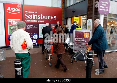 Gloucester, Großbritannien. März 2020. Ein Wachmann überprüft das Alter der Käufer, die im Sainsburys Gloucester Quays Store ankommen, für die frühe Eröffnung, die auf ältere und verletzliche Käufer aufgrund des Covid-19-/Coronavirus Ausbruchs in Großbritannien abzielt. . Mehr als 200 Käufer kamen in weniger als einer Stunde. Kredit: Andrew Higgins/Thousand Word Media Ltd/Alamy Live News Stockfoto