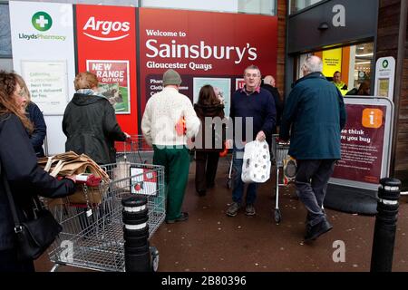 Gloucester, Großbritannien. März 2020. Ein Wachmann überprüft das Alter der Käufer, die im Sainsburys Gloucester Quays Store ankommen, für die frühe Eröffnung, die auf ältere und verletzliche Käufer aufgrund des Covid-19-/Coronavirus Ausbruchs in Großbritannien abzielt. . Mehr als 200 Käufer kamen in weniger als einer Stunde. Kredit: Andrew Higgins/Thousand Word Media Ltd/Alamy Live News Stockfoto