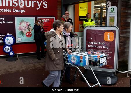 Gloucester, Großbritannien. März 2020. Ein Wachmann überprüft das Alter der Käufer, die im Sainsburys Gloucester Quays Store ankommen, für die frühe Eröffnung, die auf ältere und verletzliche Käufer aufgrund des Covid-19-/Coronavirus Ausbruchs in Großbritannien abzielt. . Mehr als 200 Käufer kamen in weniger als einer Stunde. Kredit: Andrew Higgins/Thousand Word Media Ltd/Alamy Live News Stockfoto