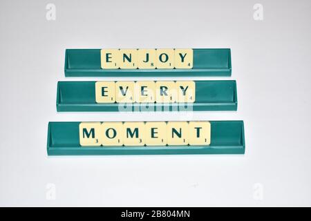 Scrabble Fliesen machen jeden Moment Spaß. Motivationszitat Scrabble blockiert Briefe Grauer Hintergrund Lebenszitat induzieren Alphabet. Stockfoto