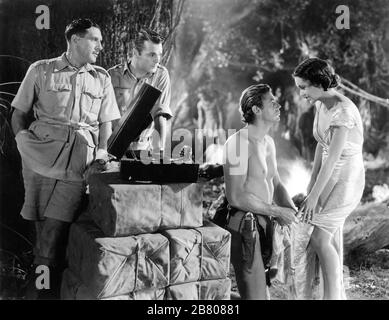 PAUL CAVANAGH als Martin Arlington NEIL HAMILTON als Harry holt JOHNNY WEISSMULLER als Tarzan und MAUREEN O'SULLIVAN als Jane Parker mit altem Plattenspieler in TARZAN UND SEINEN KUMPEL 1934 Direktoren CEDRIC GIBBONS und JACK CONWAY-FIGUREN EDGAR RICE BURROUGHS Foto von TED ALLAN Metro Goldwyn Mayer Stockfoto