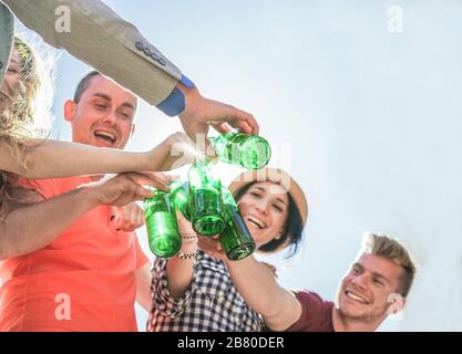 Fröhliche Freunde jubeln mit Bierflaschen bei Partyauern - junge Trendsleute haben Spaß beim Trinken und Lachen - Flaschenfokus - Jugend, friendshi Stockfoto