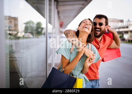 Junges attraktives glückliches Paar mit Einkaufstaschen im Freien Stockfoto