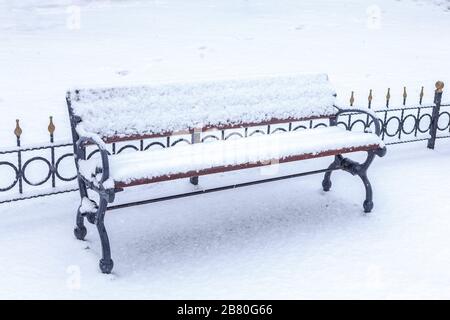 Leere Bank im schneebedeckten Park Stockfoto