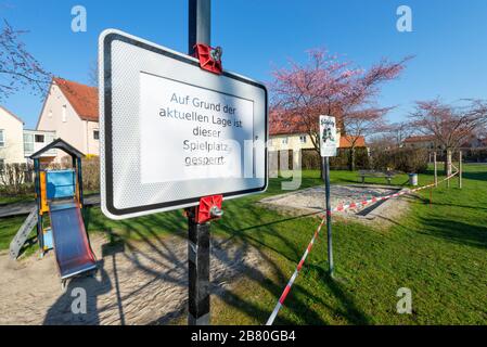 Verbotsschild und rot-weißes Absperrband an einem verschlossenen Kinderspielplatz während der Corona-Krise in Deutschland Stockfoto