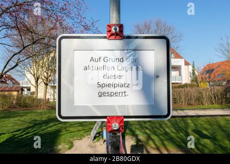 Verbotsschild und rot-weißes Absperrband an einem verschlossenen Kinderspielplatz während der Corona-Krise in Deutschland Stockfoto