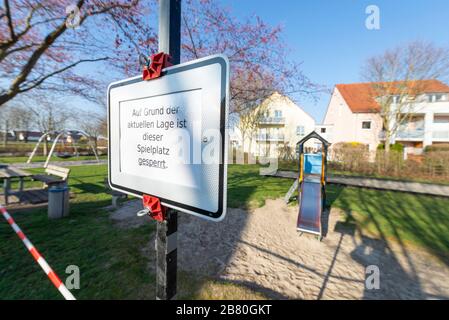 Verbotsschild und rot-weißes Absperrband an einem verschlossenen Kinderspielplatz während der Corona-Krise in Deutschland Stockfoto