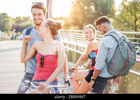 Studenten Freunde, die mit Fahrrädern auf dem Stadtpark fahren - Jugendliche, die sich am sonnigen Tag nach der Unität lustig machen - Jugend, Freundschaft und gesundes Lifestyle-Co Stockfoto