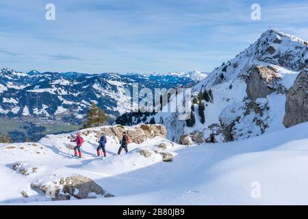 Gruppe von 3 aktiven Senioren Schneeschuhwandern im Bregenzer wald oberhalb der Ortschaft Bezau, Vorarlberg, Österreich Stockfoto
