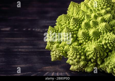 Romanesco Broccoli auf dunklem Holzhintergrund. Für Veganer und eine gesunde Ernährung. Stockfoto