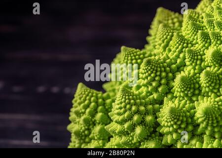 Romanesco Broccoli auf dunklem Holzhintergrund. Für Veganer und eine gesunde Ernährung. Stockfoto