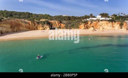 Junge Leute in einer praktischen Surfstunde stehen mit Oaren auf den Bretter. Portugal Algarve Stockfoto