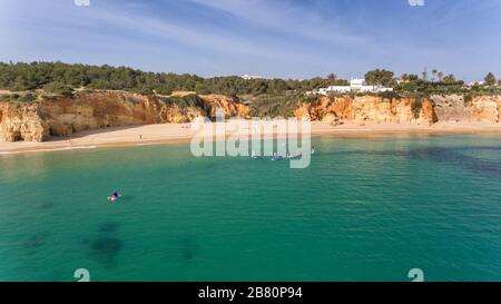 Junge Leute in einer praktischen Surfstunde stehen mit Oaren auf den Bretter. Portugal Algarve Stockfoto