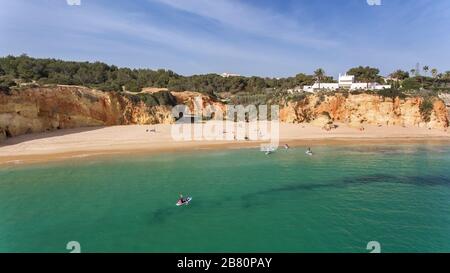 Junge Leute in einer praktischen Surfstunde stehen mit Oaren auf den Bretter. Portugal Algarve Stockfoto