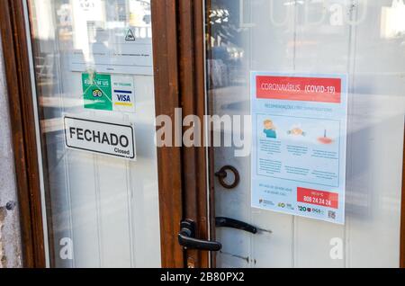 Faro, Portugal - 16. März 2020: Verschlossene Haustür des Restaurants mit einer Broschüre mit Sicherheitsanweisungen zu Coronavirus in Portugiesisch und Englisch. Die Restaurants sind wegen COVID-19-Ausbruchs geschlossen. Stockfoto