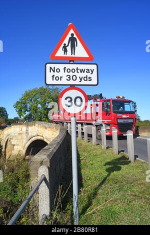 LKW, der keinen Fußraum für Fußgänger in vorausfahrender Straße passiert, Warnschild auf der Brücke, die den Fluss derwent in sutton auf derwent united überquert Stockfoto