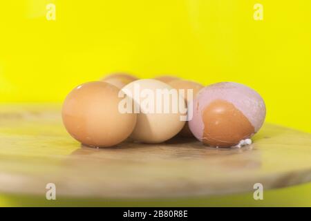 Gekochte Eier auf Holzplatte, gelber Hintergrund, Kopierraum. Stockfoto