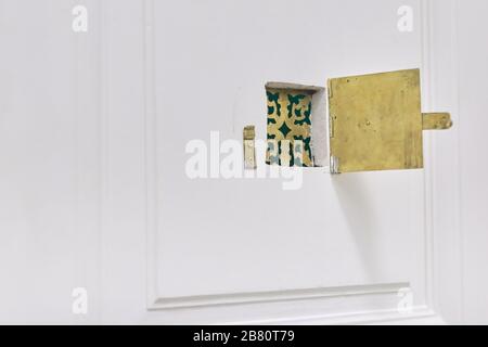 Goldenes goldenes Peephole aus altem Metall in der Vordertür. Stockfoto