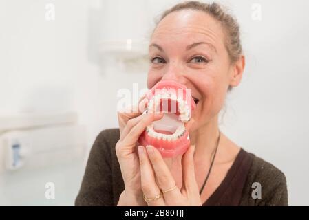 Junge lustige Frau, die mit Kiefer in der Zahnarztklinik spielt Stockfoto