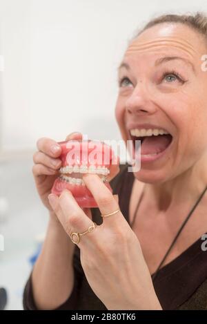 Junge lustige Frau, die mit Kiefer in der Zahnarztklinik spielt Stockfoto