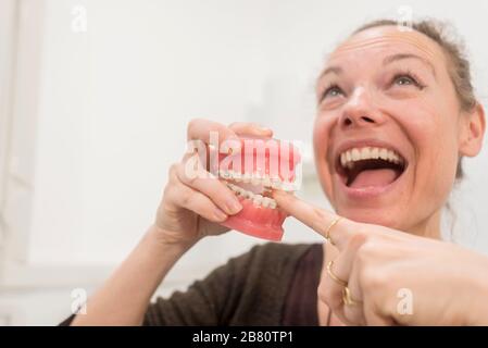 Junge lustige Frau, die mit Kiefer in der Zahnarztklinik spielt Stockfoto