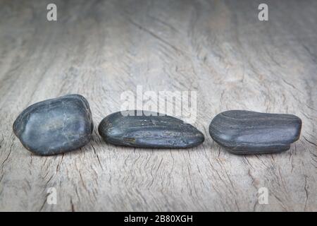 Runde Steine auf Holzstruktur für ein Spa. Stockfoto