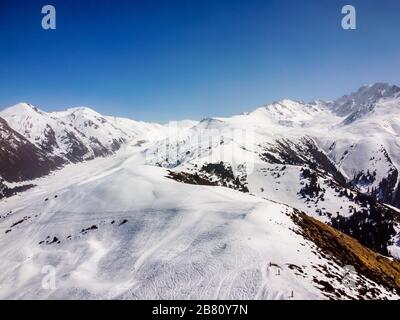 Blick auf die Winterberge und den blauen Himmel. Querformat. Winter Natur. Flug über Skibasis. Terskey Alatoo Mountains, Tian-Shan, Karakol, Kirgisistan. Stockfoto