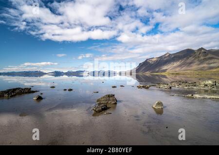 vestrahorn im Süden Islands, Spiegelung in ruhigem Wasser über schwarzem vulkanischen Strand, Landschaftsfotografie Stockfoto