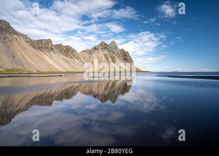 vestrahorn im Süden Islands, Spiegelung in ruhigem Wasser über schwarzem vulkanischen Strand, Landschaftsfotografie Stockfoto