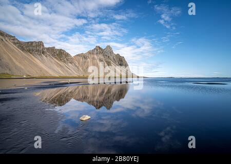 vestrahorn im Süden Islands, Spiegelung in ruhigem Wasser über schwarzem vulkanischen Strand, Landschaftsfotografie Stockfoto