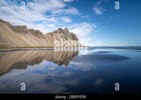 vestrahorn im Süden Islands, Spiegelung in ruhigem Wasser über schwarzem vulkanischen Strand, Landschaftsfotografie Stockfoto