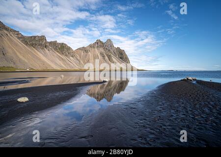 vestrahorn im Süden Islands, Spiegelung in ruhigem Wasser über schwarzem vulkanischen Strand, Landschaftsfotografie Stockfoto