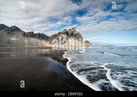 vestrahorn im Süden Islands, Spiegelung in ruhigem Wasser über schwarzem vulkanischen Strand, Landschaftsfotografie Stockfoto